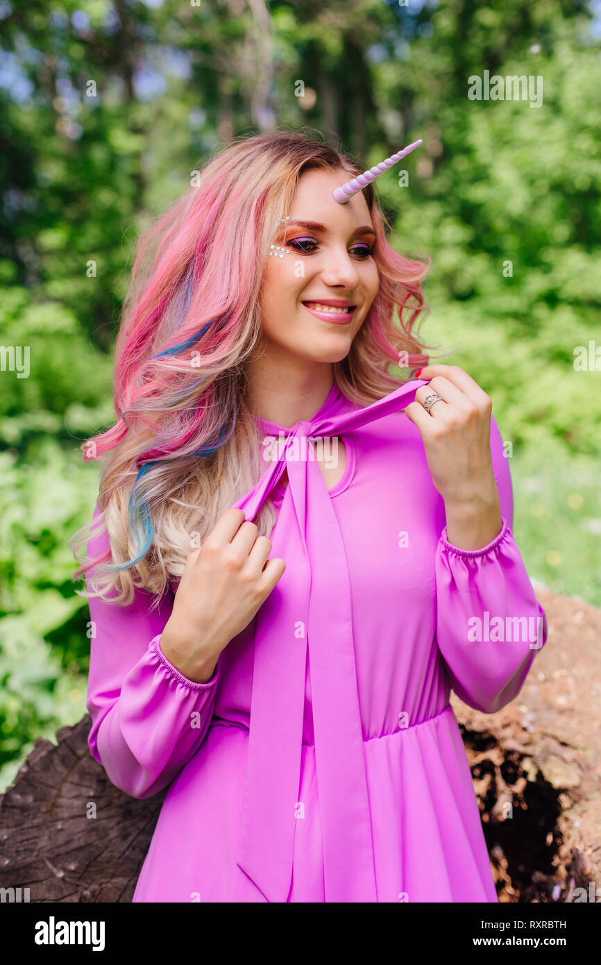 Fairy chica unicornio con arco iris cabello y maquillaje brillante en el  bosque Fotografía de stock - Alamy