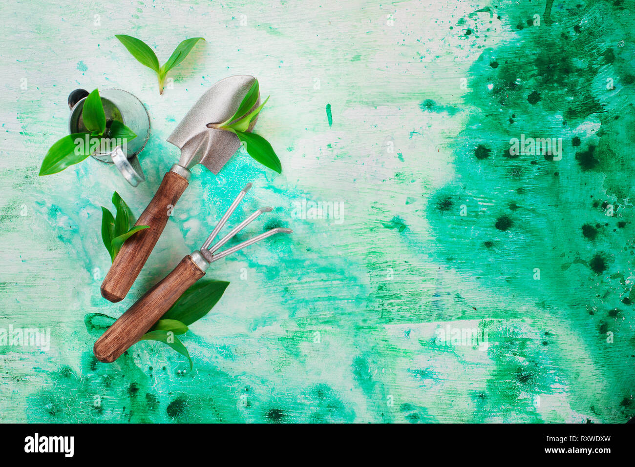 Herramientas de jardinería con hojas verdes sobre un fondo de acuarela con espacio de copia Foto de stock