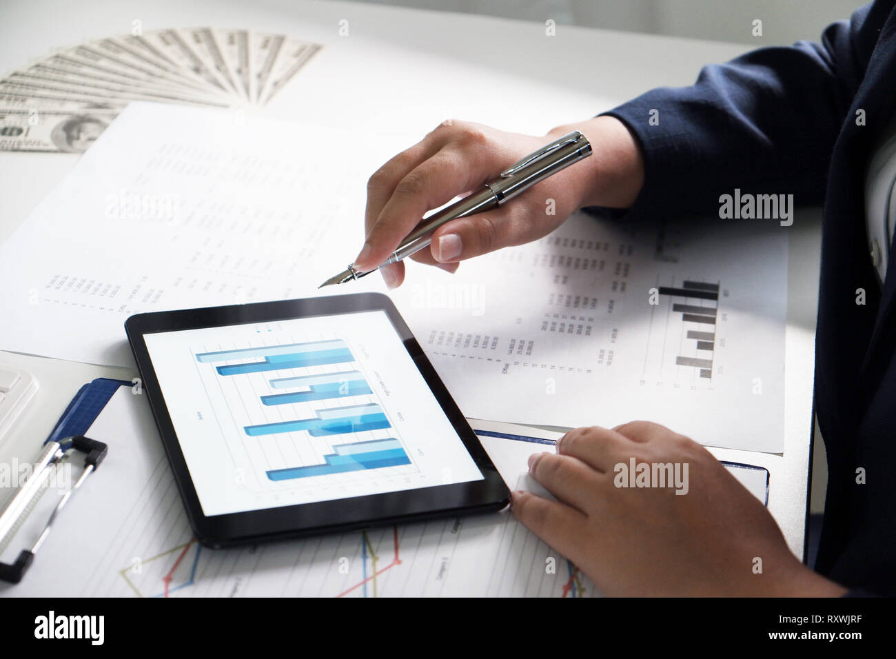 Las mujeres que trabajan en la oficina. El análisis financiero con gráficos en pad para negocios, contabilidad, seguros o concepto de finanzas Foto de stock
