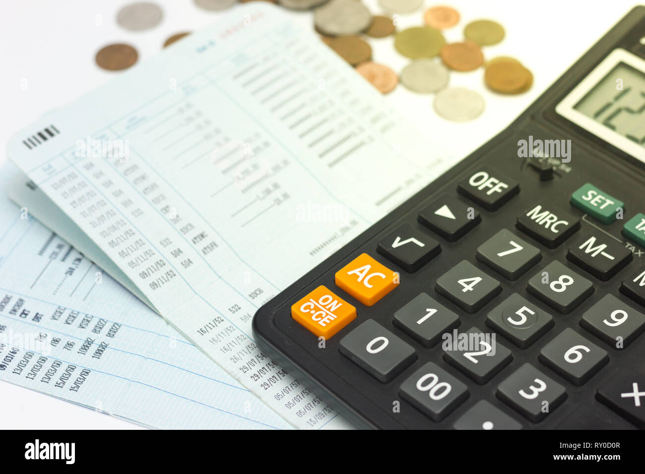 Calcular, cuenta de banco y monedas sobre fondo blanco Fotografía de stock  - Alamy