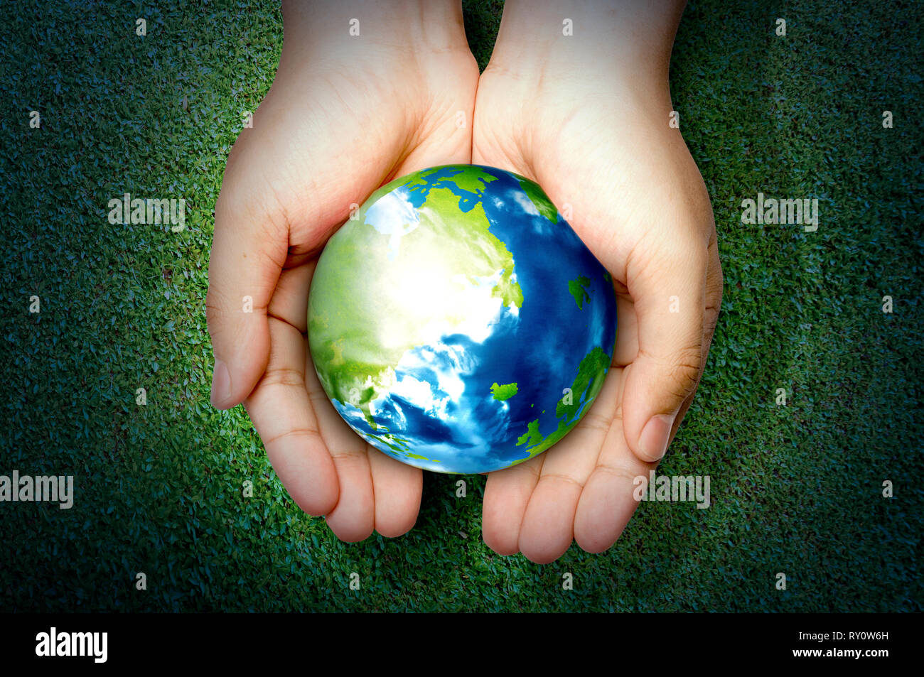 Manos sosteniendo planeta tierra sobre la hierba verde de fondo. La hora de  la tierra concepto Fotografía de stock - Alamy