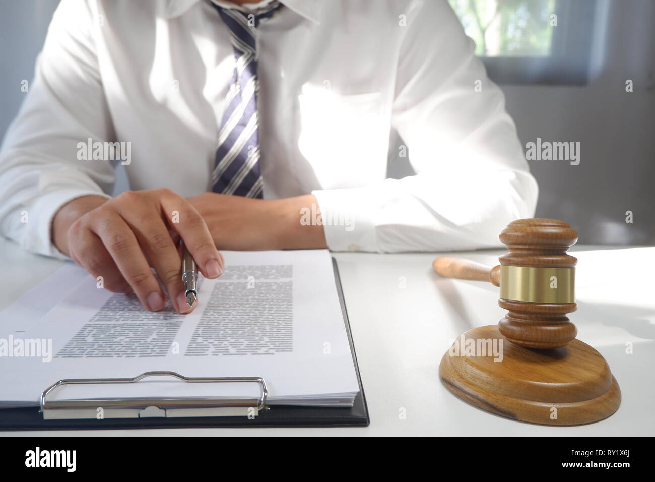 Asesor jurídico presenta un contrato con martillo y legales; la justicia y el abogado concepto Foto de stock