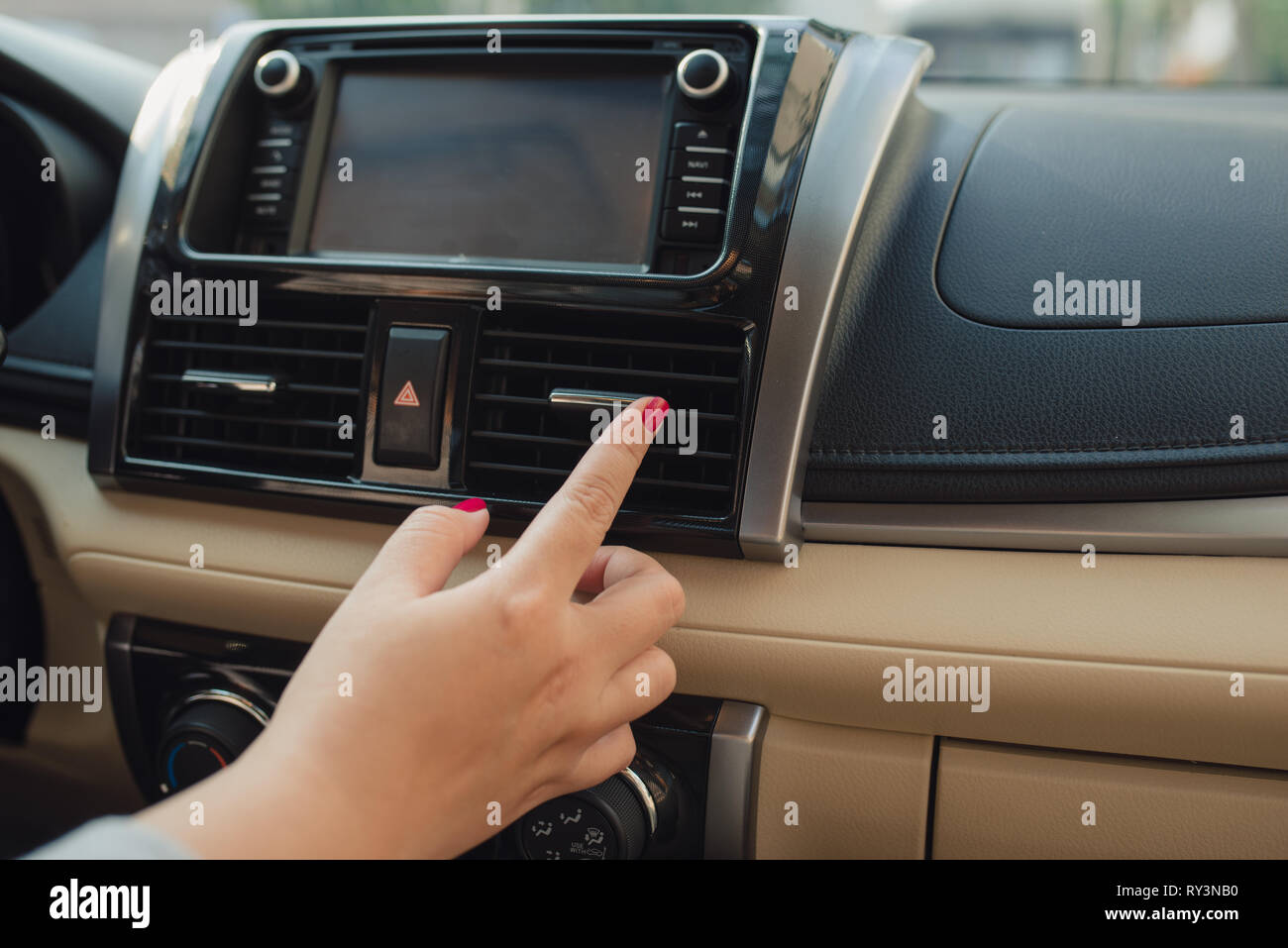 La mujer se enciende el aire acondicionado en el coche. Coche moderno  interior Fotografía de stock - Alamy