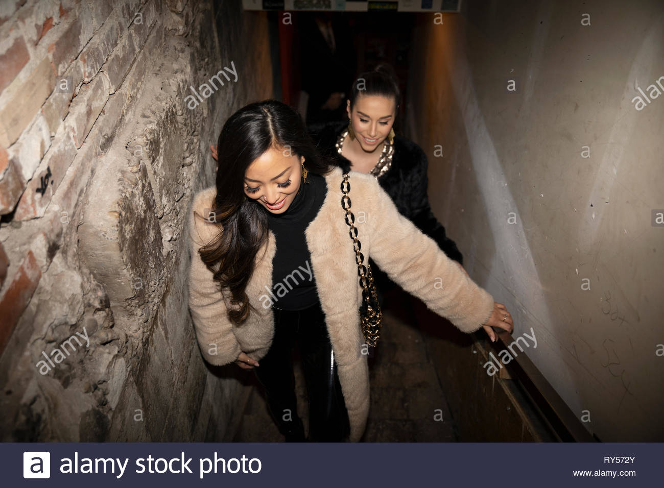Las mujeres amigos discoteca ascendente escaleras Foto de stock