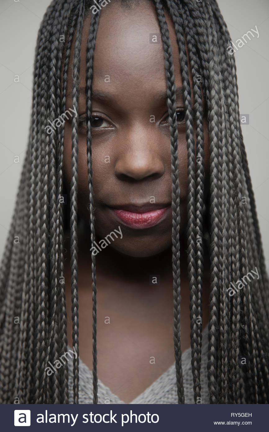 Retrato seguros hermosa joven afroamericana con largas trenzas negras Foto de stock