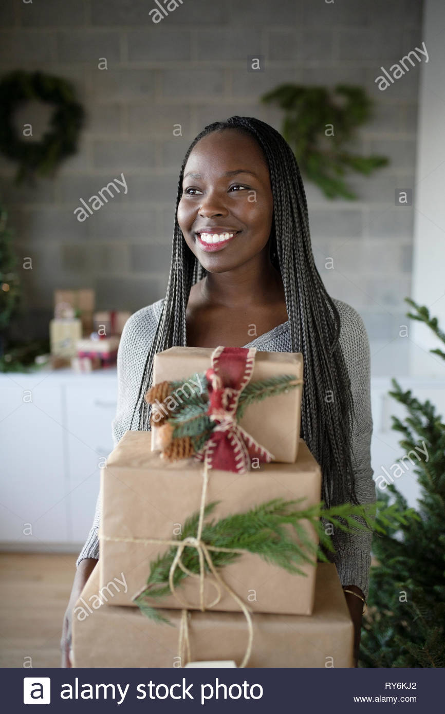 Feliz joven afroamericana sosteniendo la pila de regalos de Navidad Foto de stock