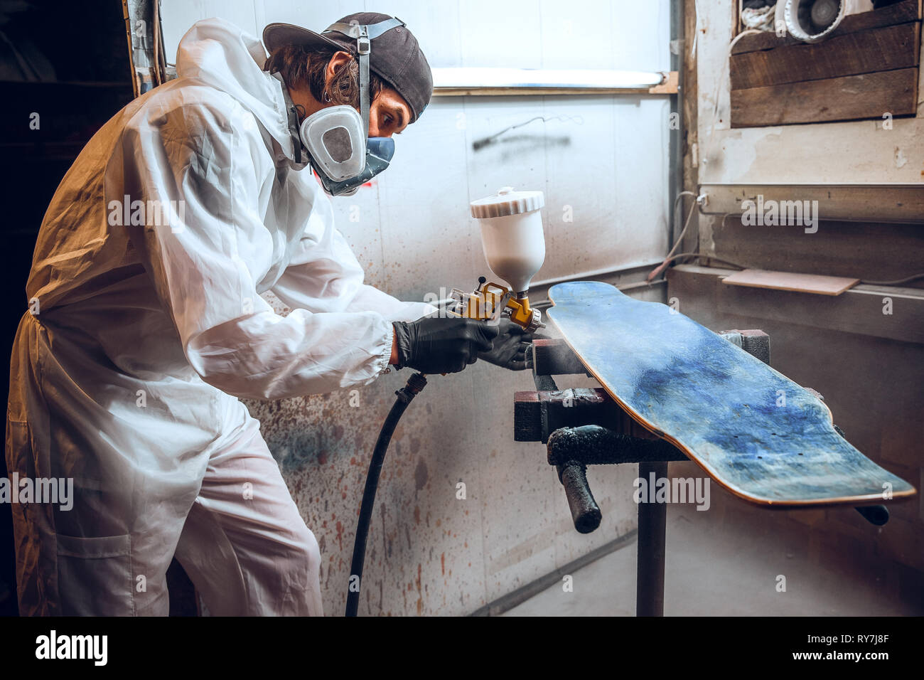 Maestro pintor en una fábrica - Pintura industrial de madera con pistola de  pulverización Fotografía de stock - Alamy