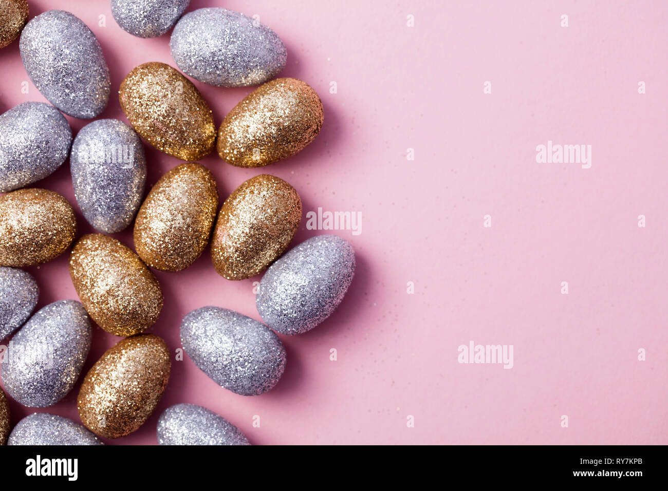 Oro y plata glitter huevos de Pascua sobre un fondo de color rosa pastel  Fotografía de stock - Alamy
