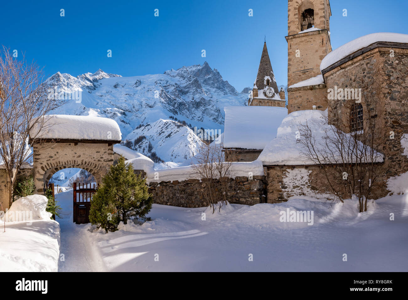 La Tumba, Hautes-Alpes, Parque Nacional de Ecrins, Francia: la aldea local de la tumba y su iglesia con la Meije el pico de la montaña en invierno Foto de stock