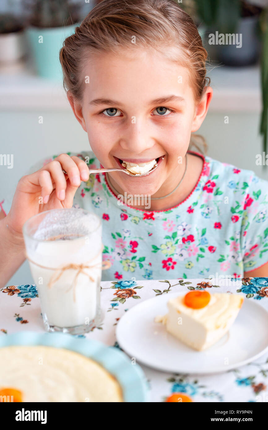 Hermosa niña desayunando y bebiendo leche en la cocina en el hogar  Fotografía de stock - Alamy