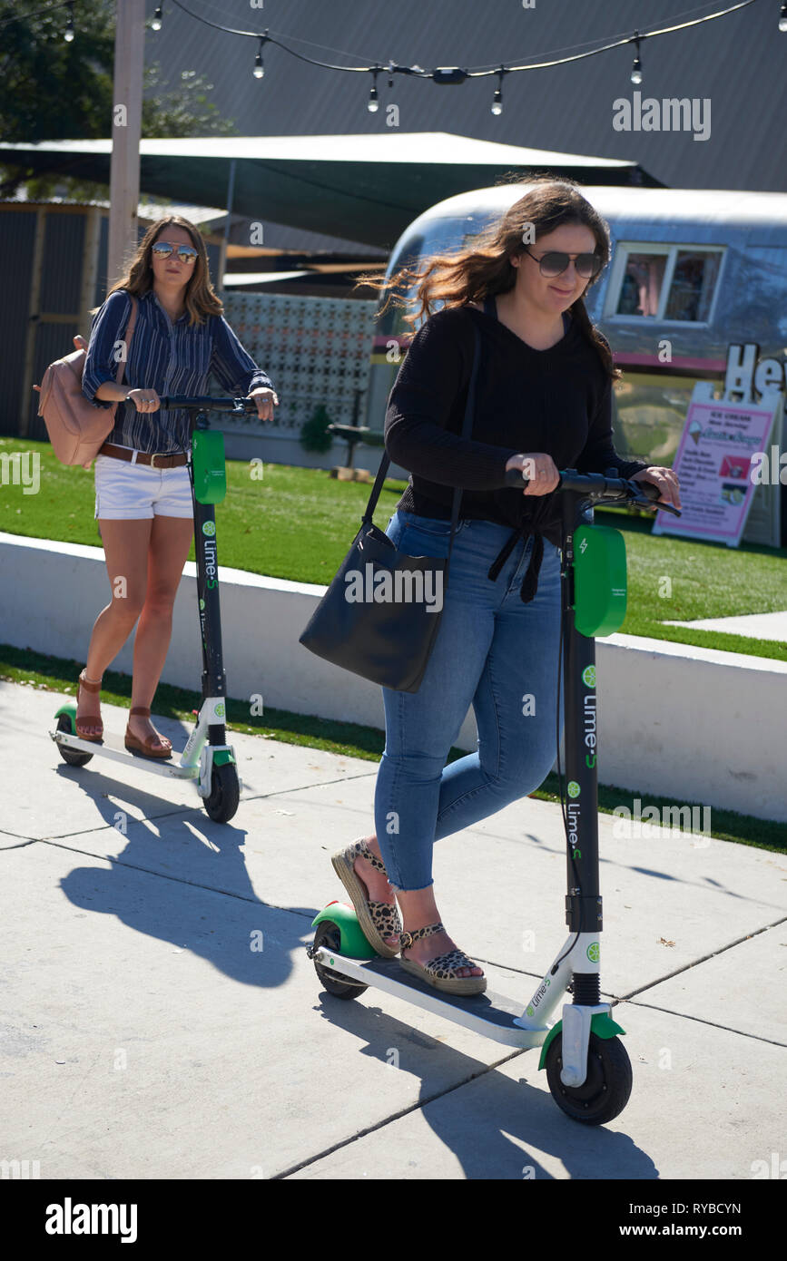 Montar las mujeres e scooters eléctricos para alquilar, South Congress Avenue, Austin, Texas Foto de stock