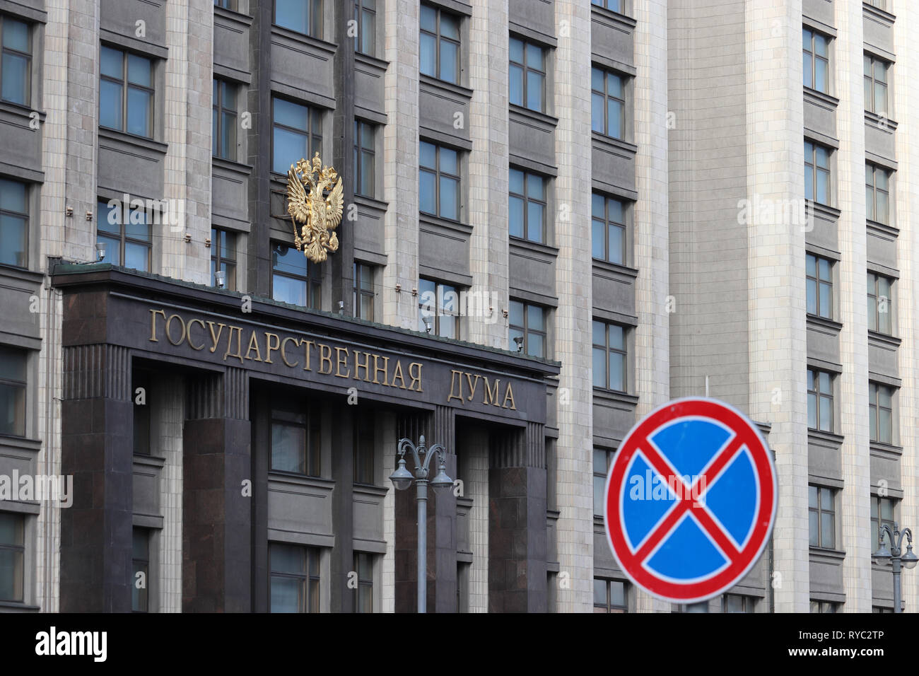 Fachada del edificio del parlamento ruso en Moscú con el emblema de Rusia y la inscripción "tate Duma'. Parada y estacionamiento prohibido es señal de carretera Foto de stock