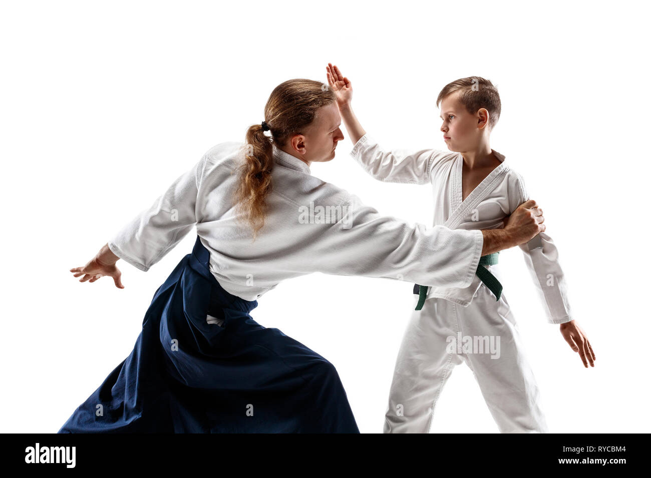 Hombre y jovencito luchando en la práctica del Aikido en la escuela de  artes marciales. Estilo de vida saludable y deportes concepto. En Fightrers  kimono blanco sobre fondo blanco. Karate hombres con