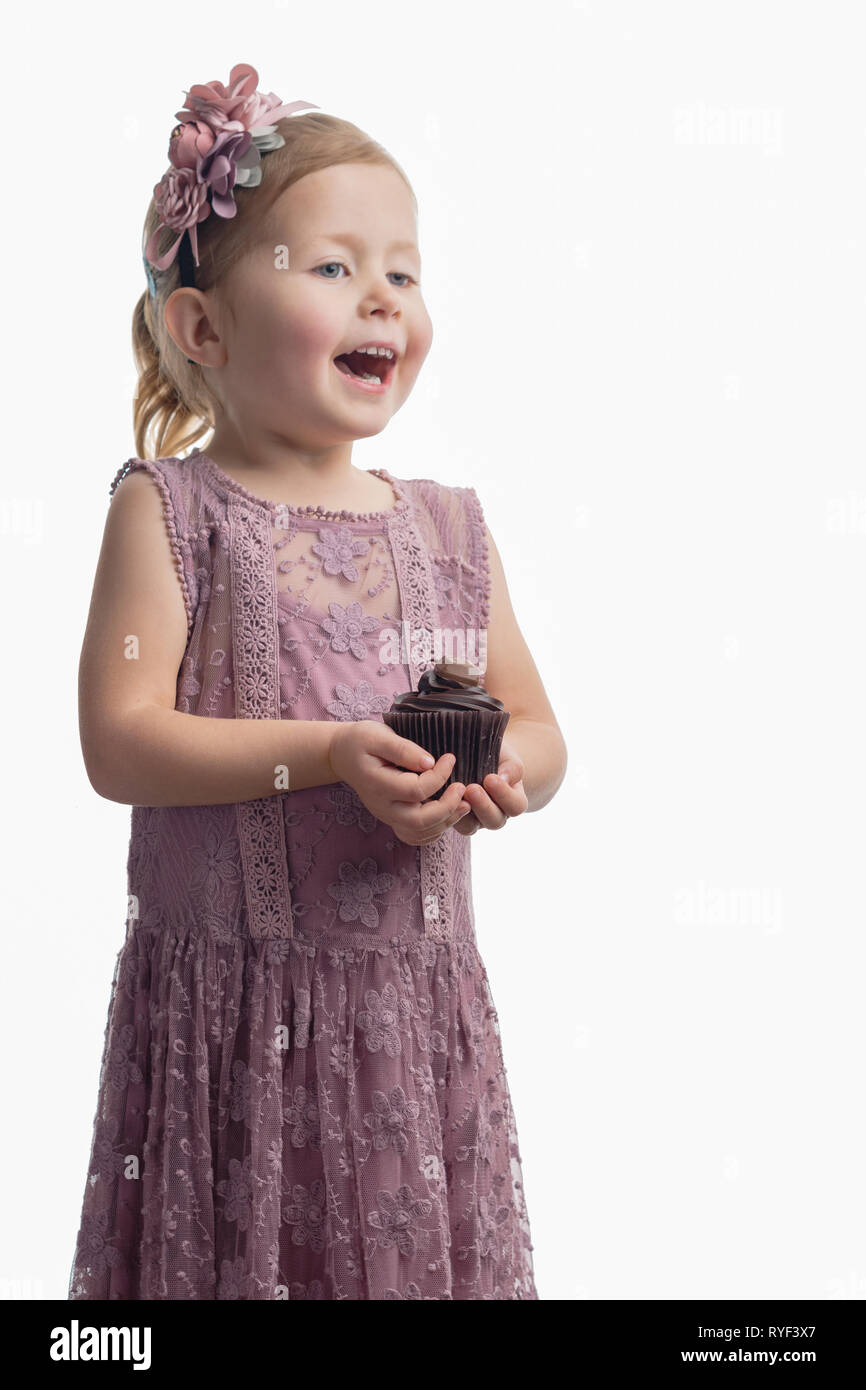Niña vestido lila pastel y diadema con flores de tejido celebración cupcake  de chocolate blanco, el enfoque selectivo Fotografía de stock - Alamy