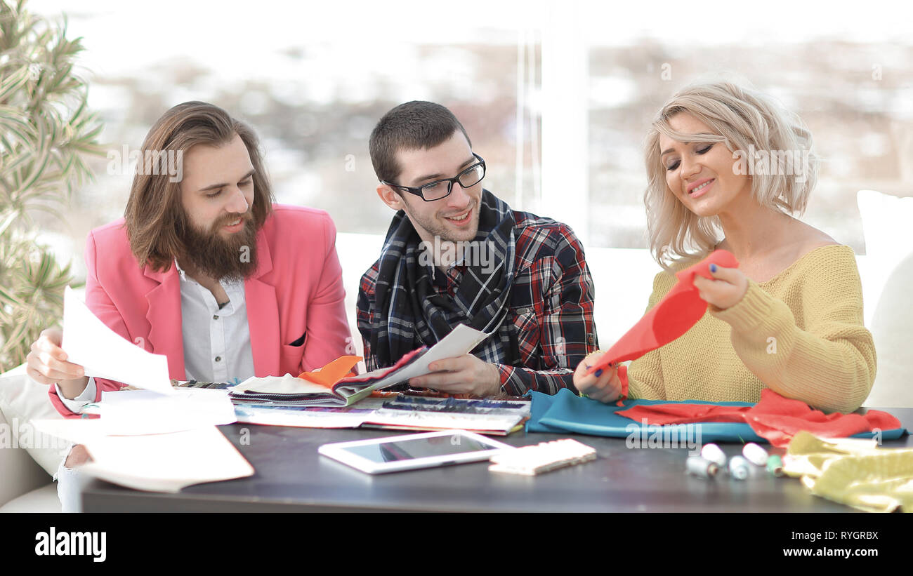 La empresaria sastre sonriente sentado en máquina de coser y hacer ropa  artesanal mientras marketing assistant trabajando en nuevos proye  Fotografía de stock - Alamy