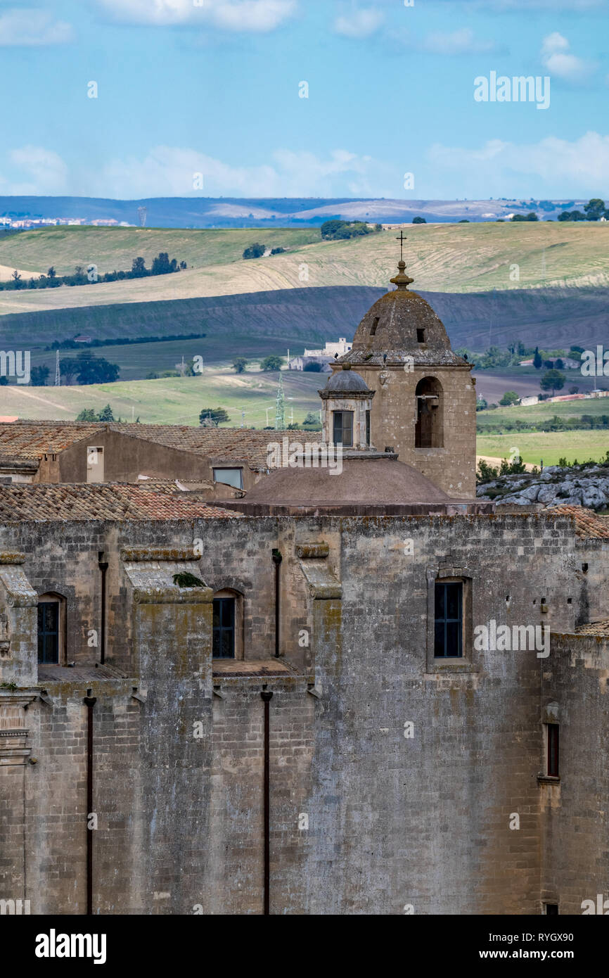 La torre de la iglesia y el techo con religioso cruz de Chiesa di Sant'Agostino, vista de la antigua ciudad de Matera, Basilicata, en el sur de Italia, nublado verano cálido día de agosto Foto de stock