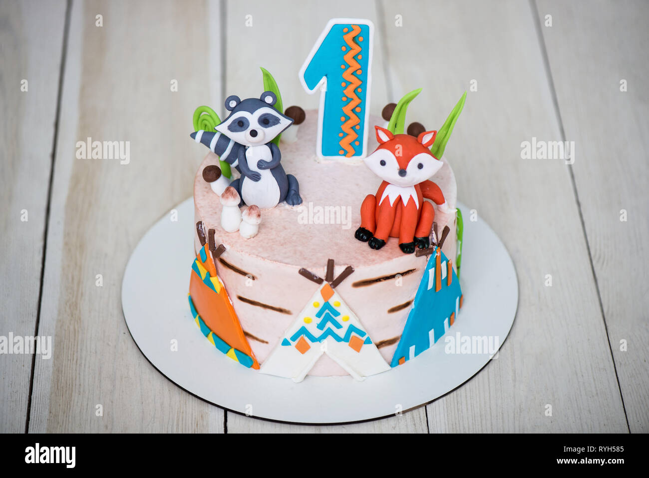 pegar Presunción estaño Cerca de chef de repostería torta de cumpleaños para 1 año de edad. Los  niños de la torta está decorado con figuras de animales, wigwam y número  uno Fotografía de stock - Alamy