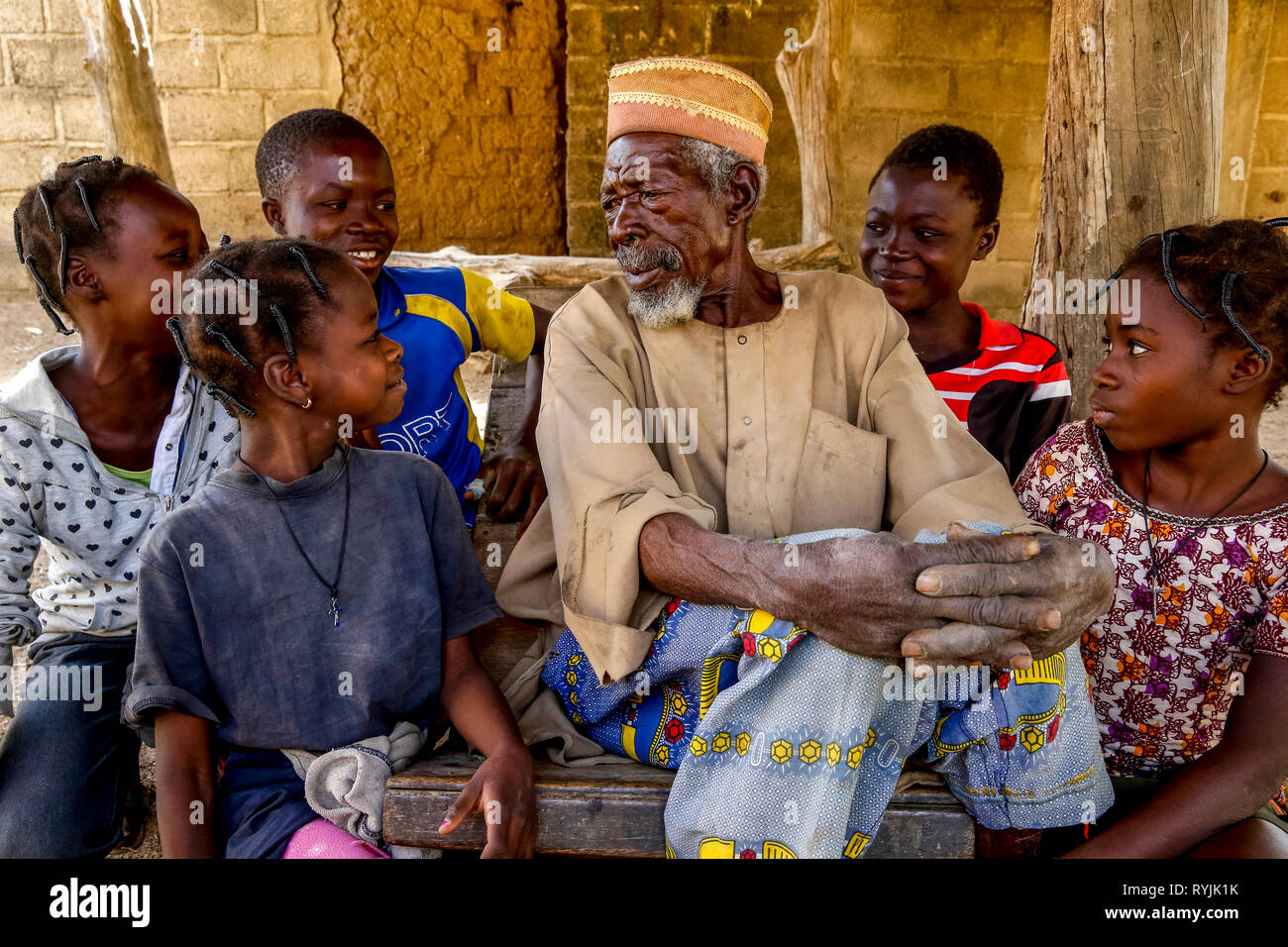 Los niños alrededor de su abuelo en Tenkodogo, Burkina Faso. Foto de stock