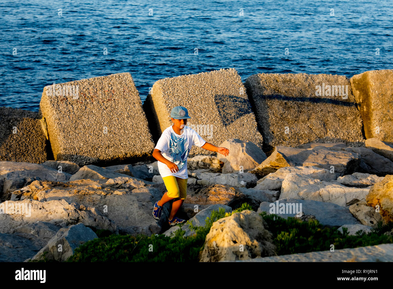 12-año-viejo muchacho caminando junto a la orilla del mar en Palermo, Sicilia (Italia). Foto de stock