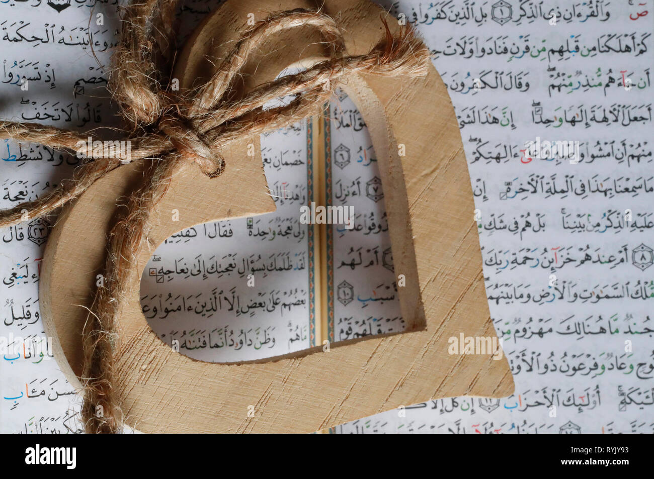 Corazón de madera escultura sobre un Corán. Close-up. Foto de stock