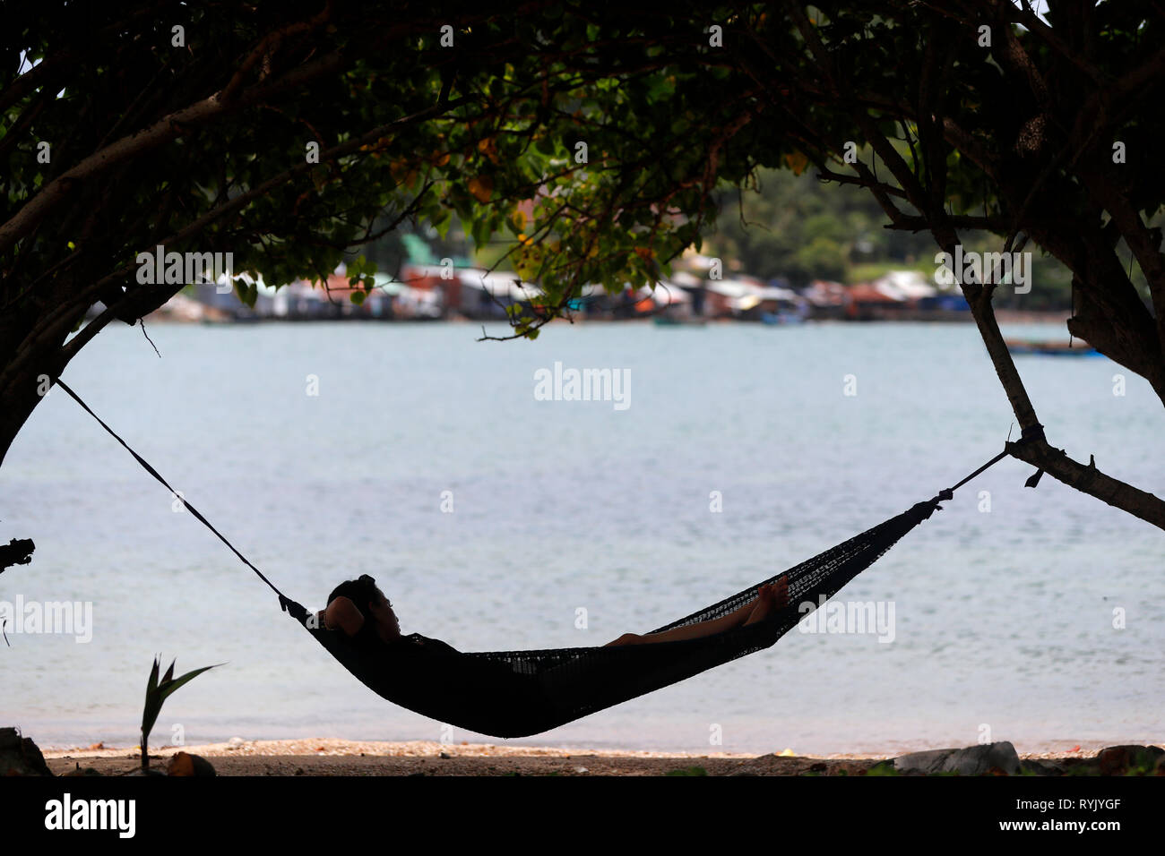 En el Mar del Sur de China. Mujer, relajarse en una playa en una hamaca. Ha Tien. Vietnam. Foto de stock