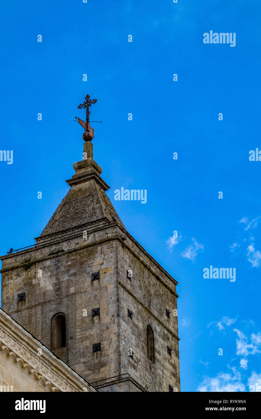 La torre de la iglesia y el techo con religioso cruz de Chiesa di Sant'Agostino, vista de la antigua ciudad de Matera, Basilicata, en el sur de Italia, nublado verano cálido día de agosto Foto de stock