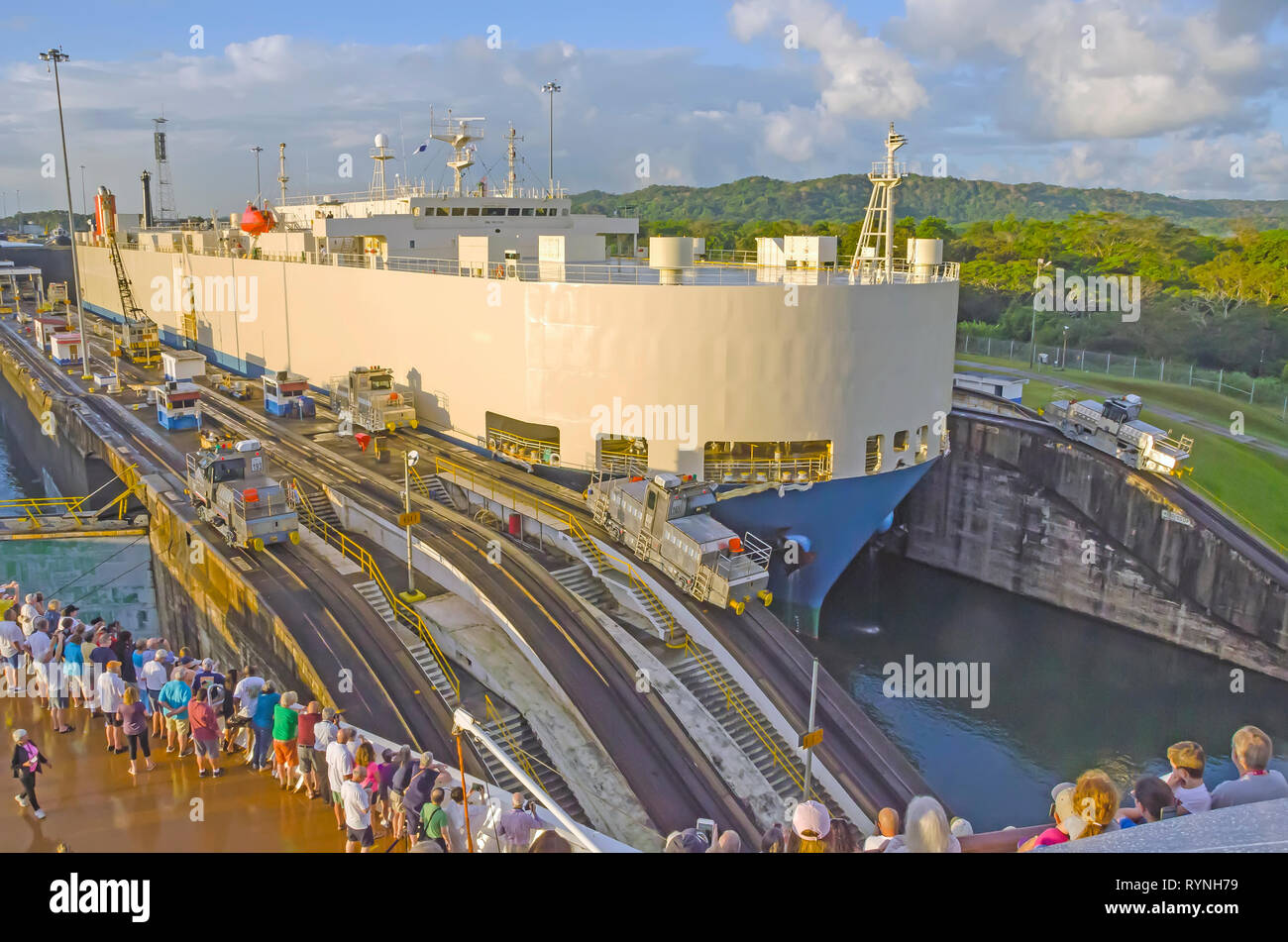 Los pasajeros de los cruceros del Canal de Panamá ver dos mulas locomotora eléctrica buque guía mediante esclusas de Gatun, República de Panamá Foto de stock