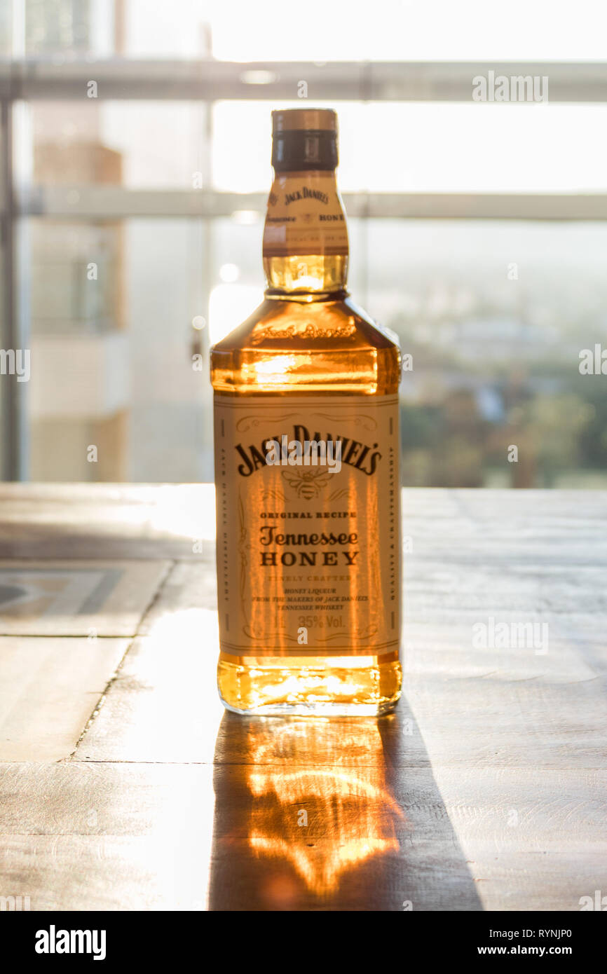Imagen vertical de Jack Daniel's miel whisky delante del sol. Foto de stock