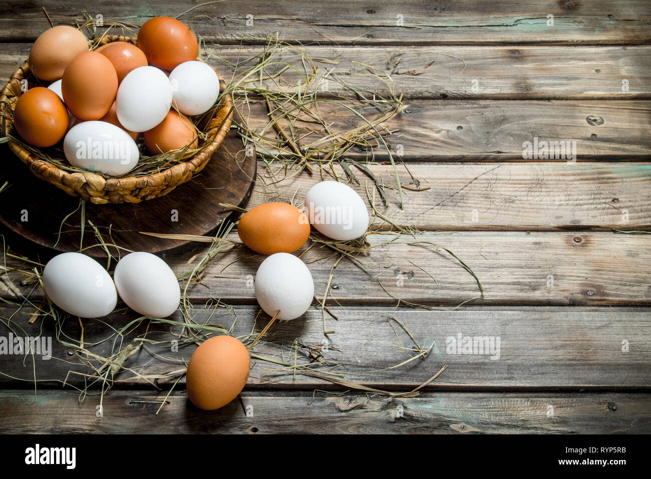 Los huevos en una canasta. Sobre un fondo de madera. Foto de stock