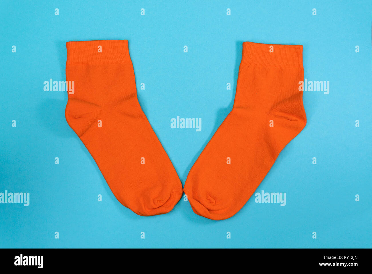 Par de calcetines, naranja nuevo fondo azul Foto de stock