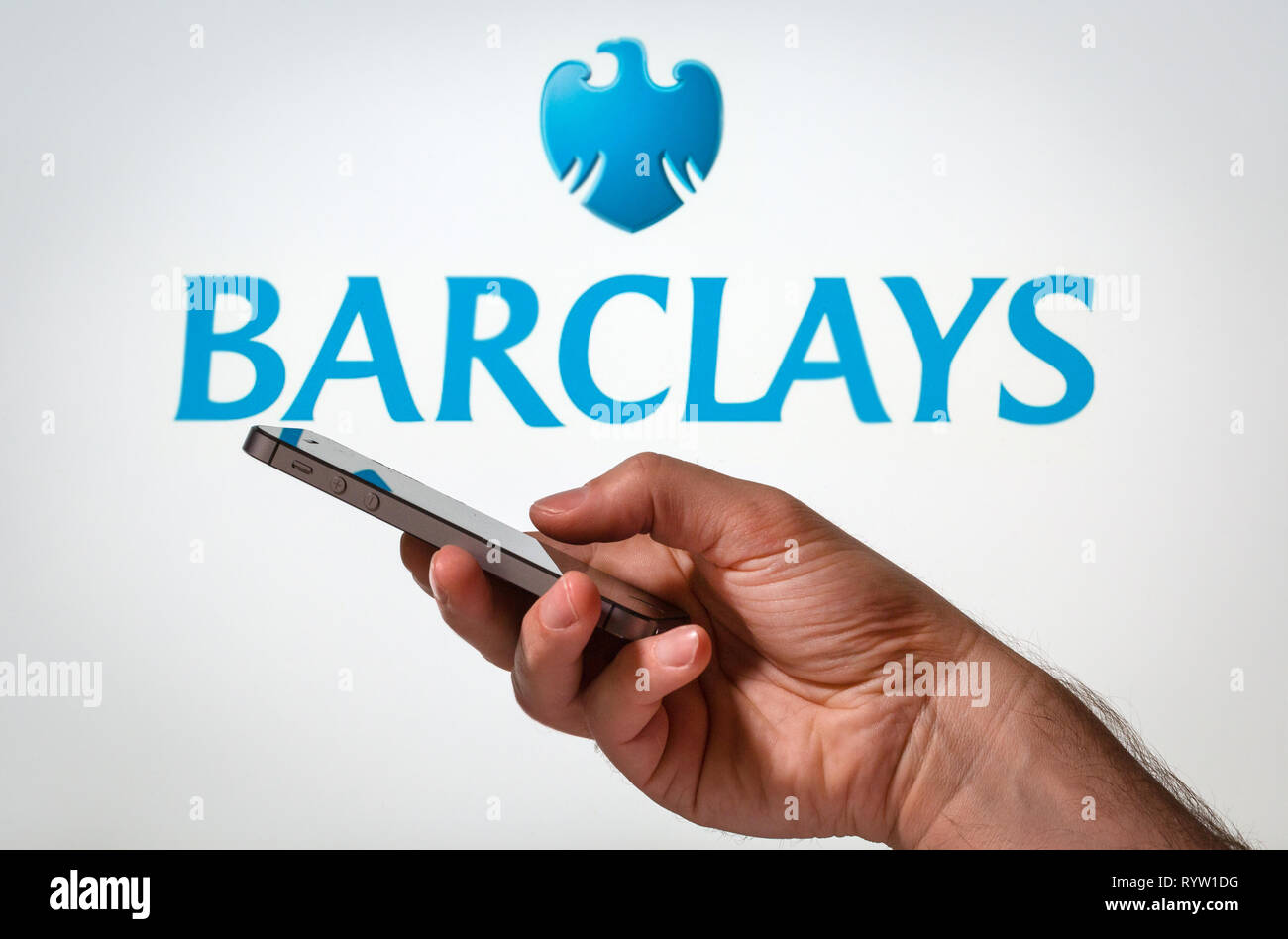Un hombre usando Barclays Bank banca en línea en su teléfono móvil Foto de stock