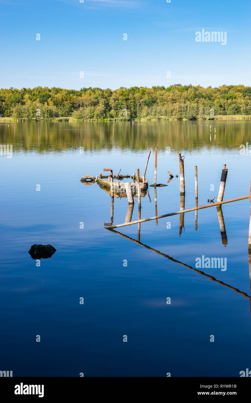 La contaminación del medio ambiente natural concepto: Rusty restos de embarcaciones y estructuras metálicas en el lago. Foto de stock