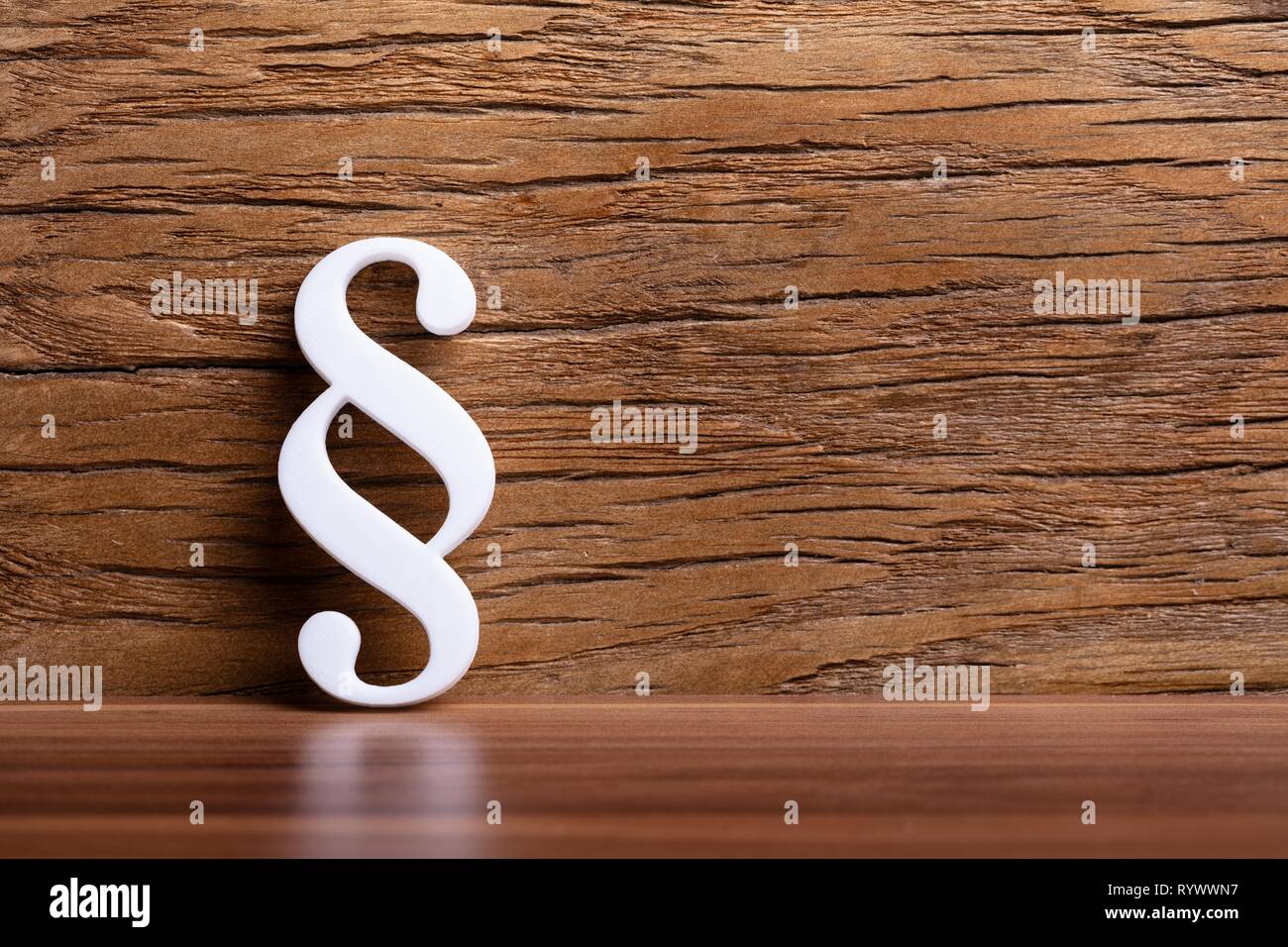 Signo de párrafo blanca recostada sobre la pared de madera Foto de stock