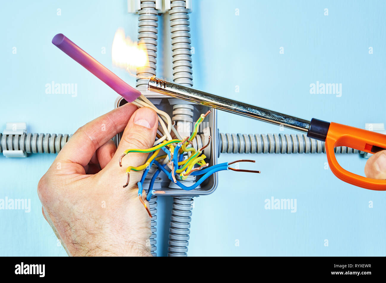 Electricista está incendiando el tubo termocontraíble para aislamiento de  hilos trenzados de la caja de empalme Fotografía de stock - Alamy