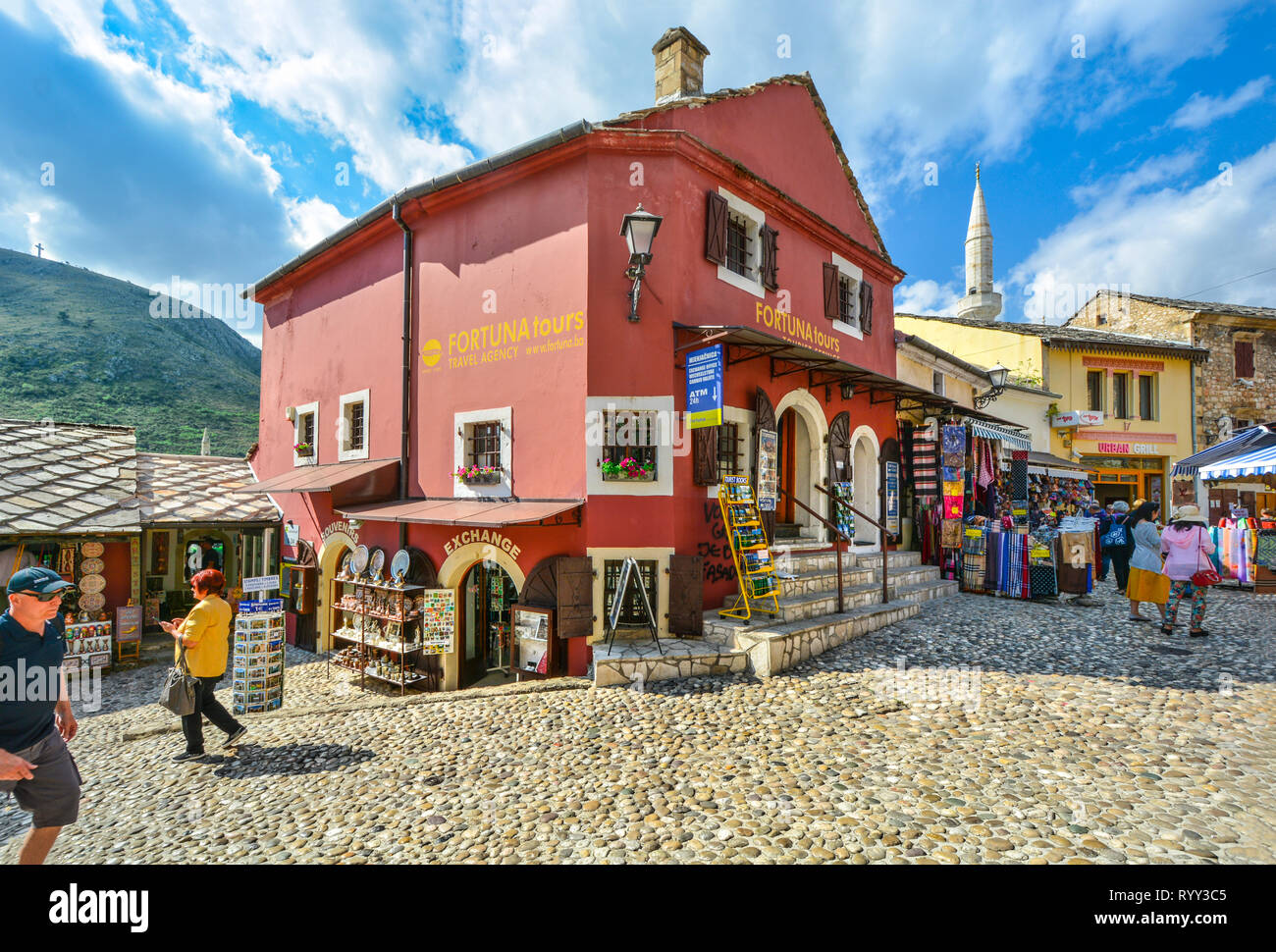 Los turistas tienda de regalos y souvenirs y errante Mostar, Bosnia del casco antiguo de la ciudad con un minarete en el fondo Foto de stock