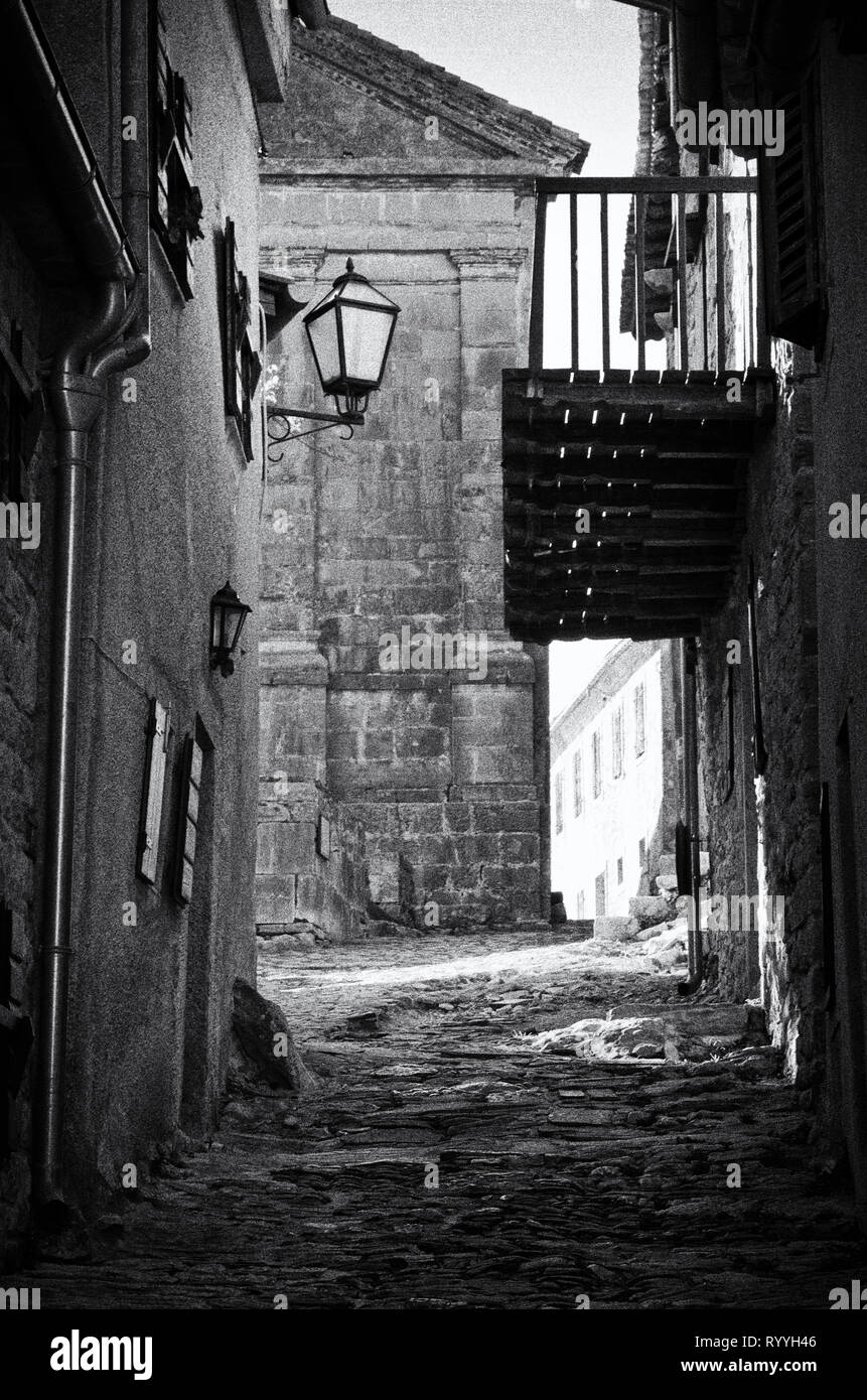 Calle antigua de piedra en una pequeña ciudad de Istria Hum, vintage la fotografía en blanco y negro, de textura granulada Foto de stock