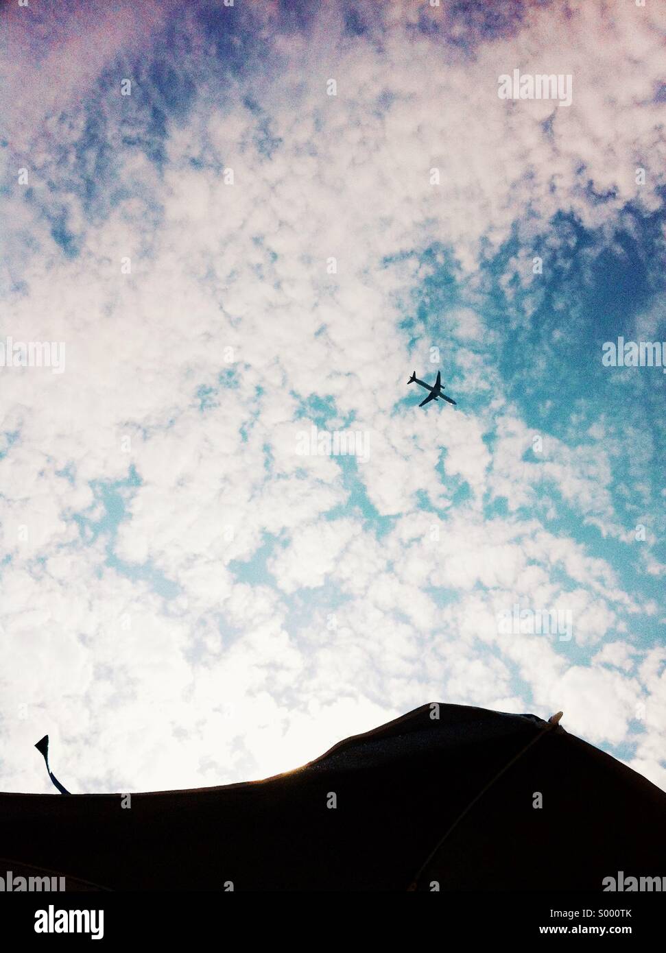 Vista hacia arriba de un avión pasando por Foto de stock