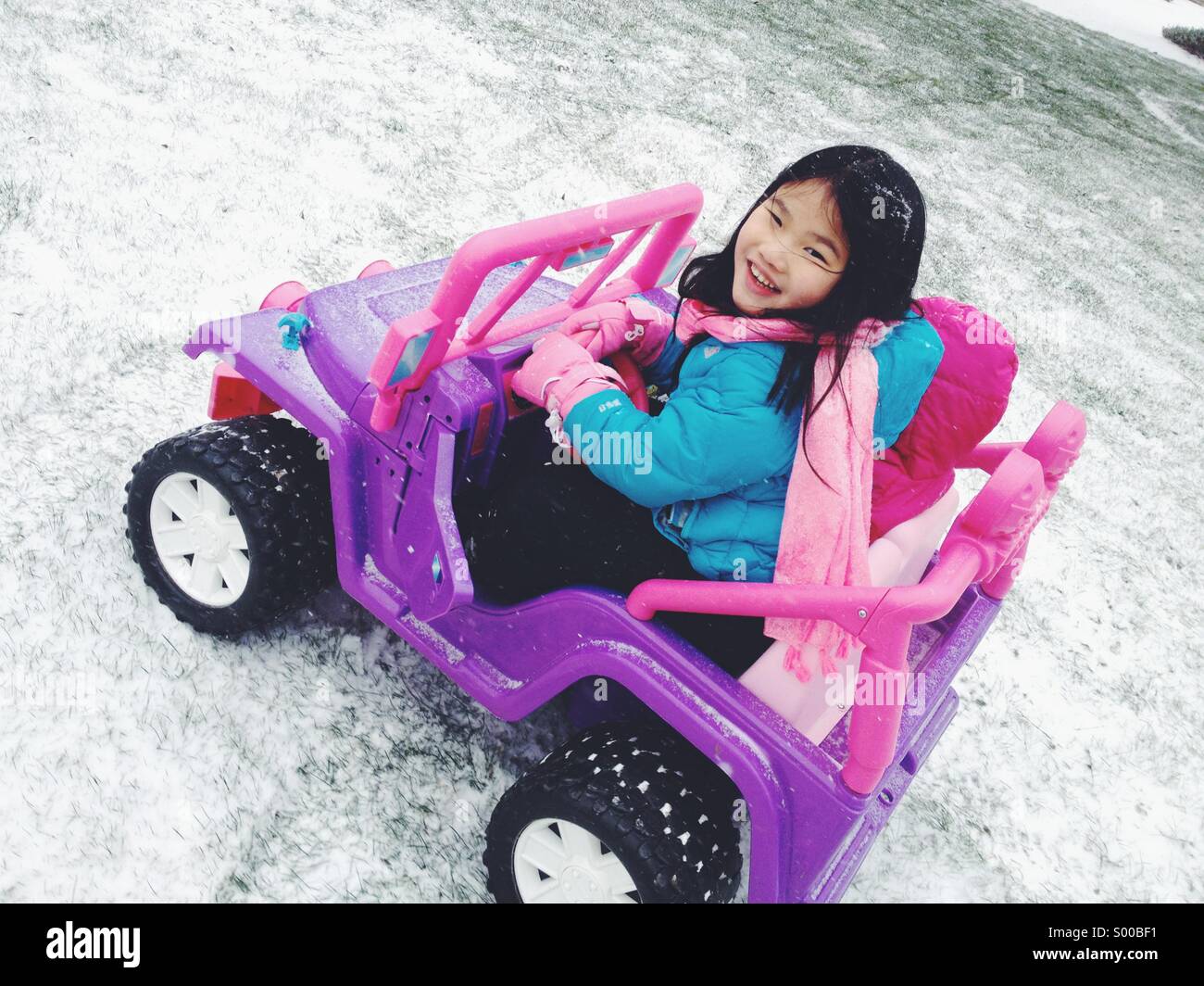 Joven chica coche de juguete en la nieve Foto de stock
