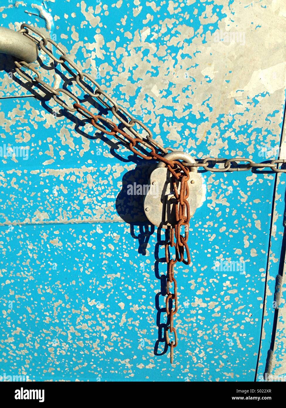 El candado y la cadena papelera de reciclaje azul Foto de stock