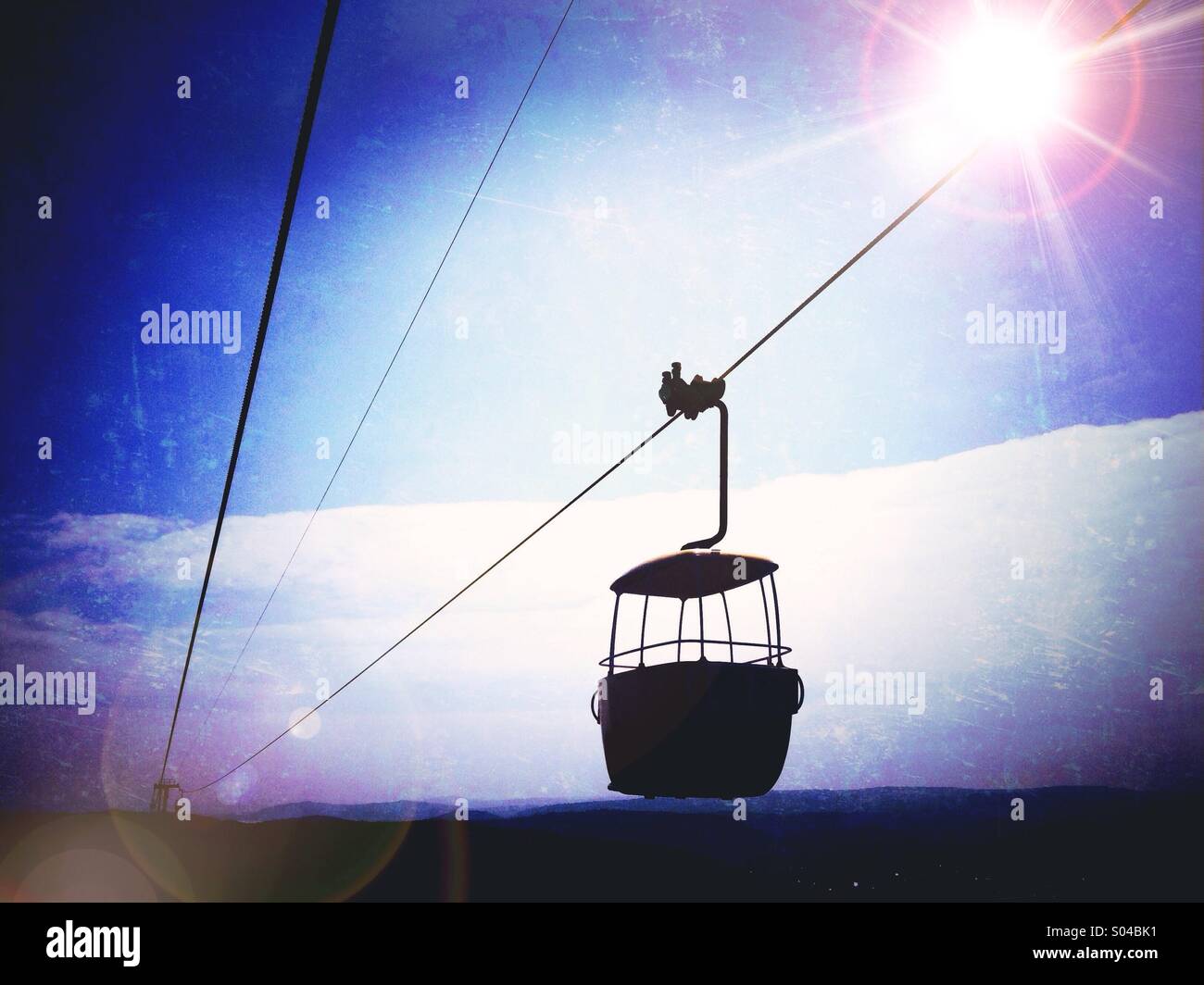El teleférico en gran orme en Llandudno silueteado contra el sol Foto de stock