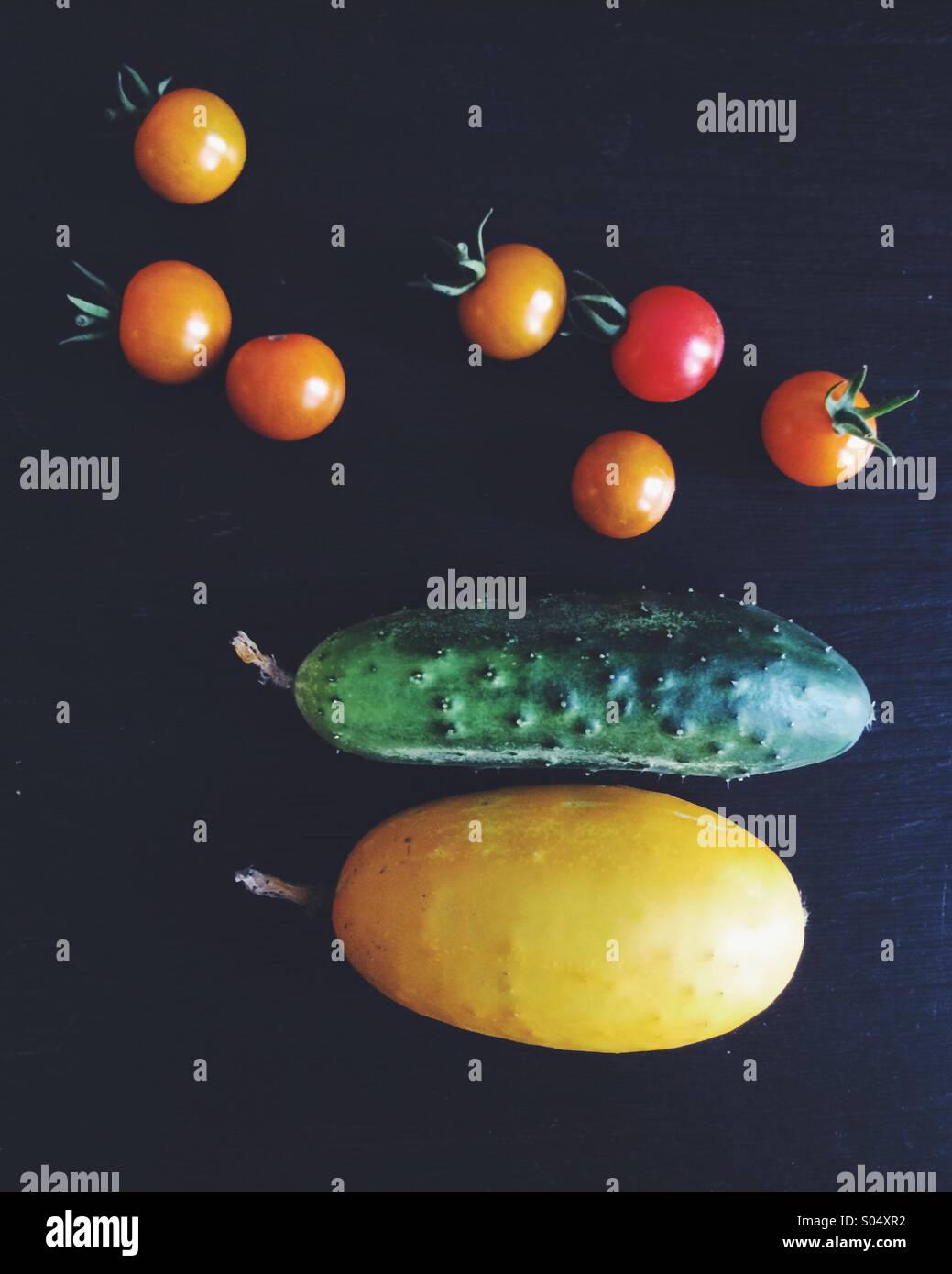 Los tomates y pepinos cosechados de un jardín. Foto de stock