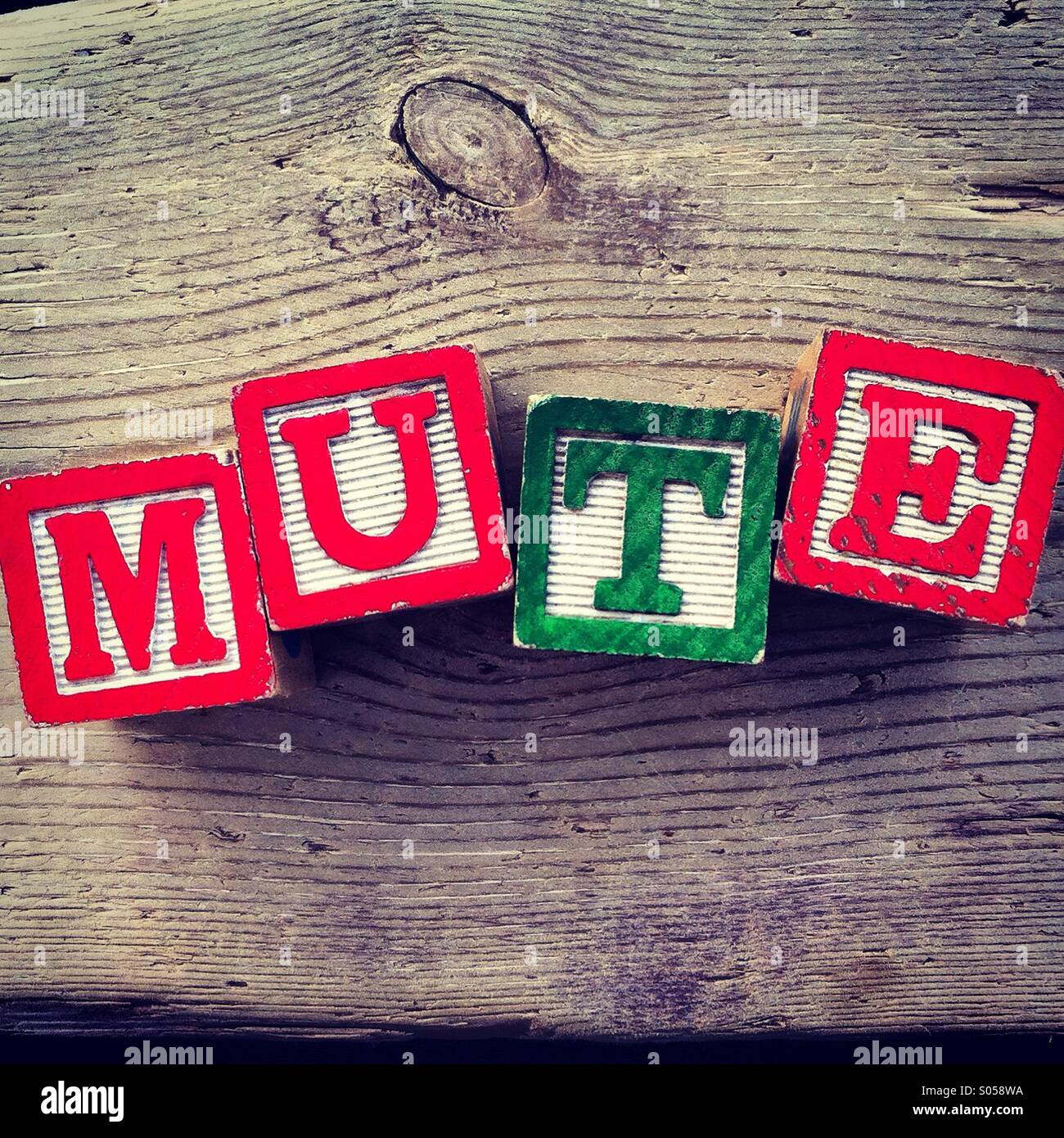 Es una foto de 4 cubos de madera juguete con letras que componen la