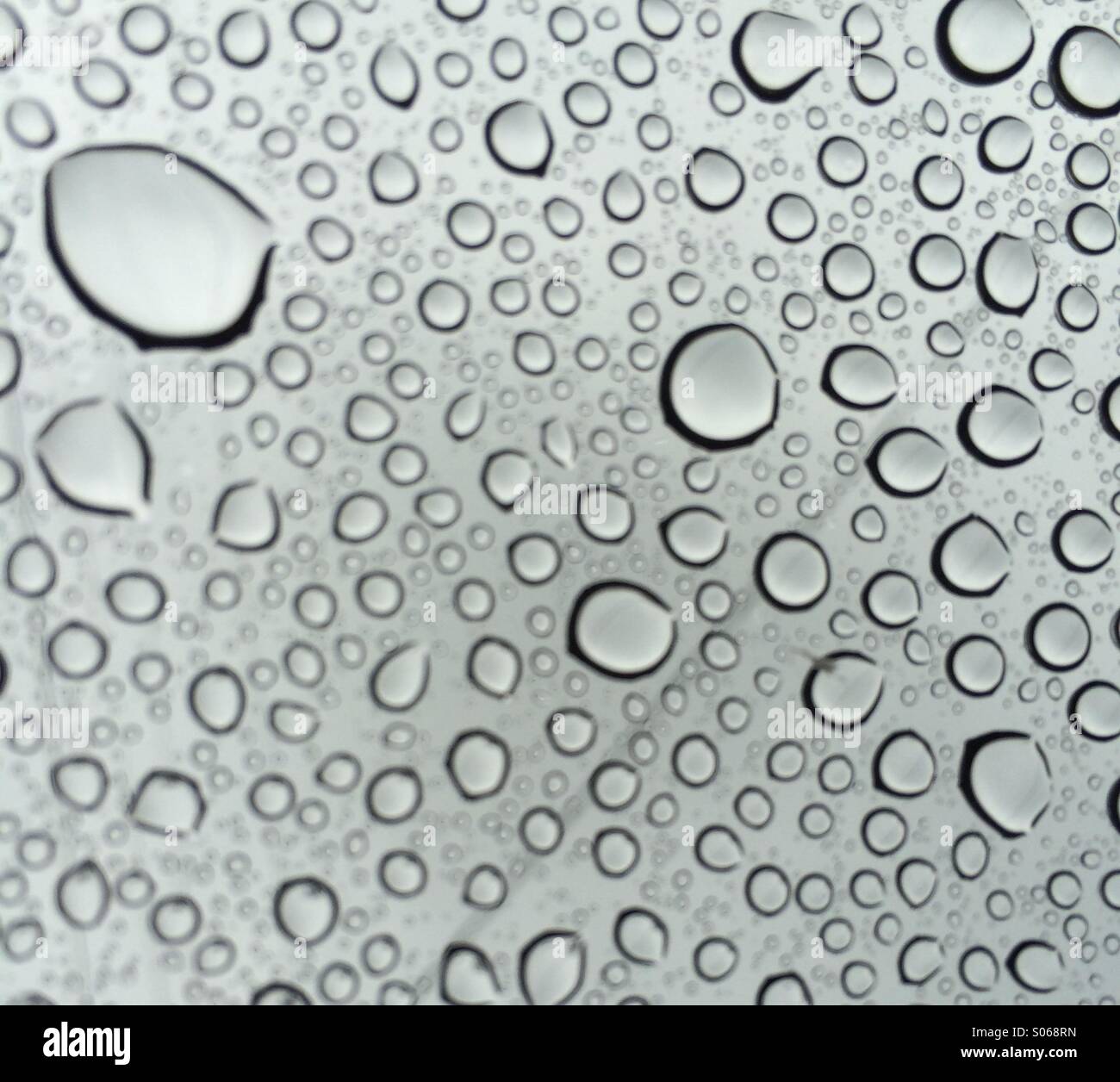 Techo solar de Seattle. Mirar a través de las gotas de lluvia al cielo gris de verano. Foto de stock