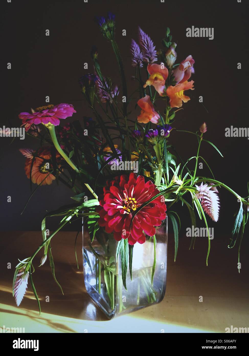 Una tarde de verano creative arreglo floral en un florero sobre una mesa. Foto de stock