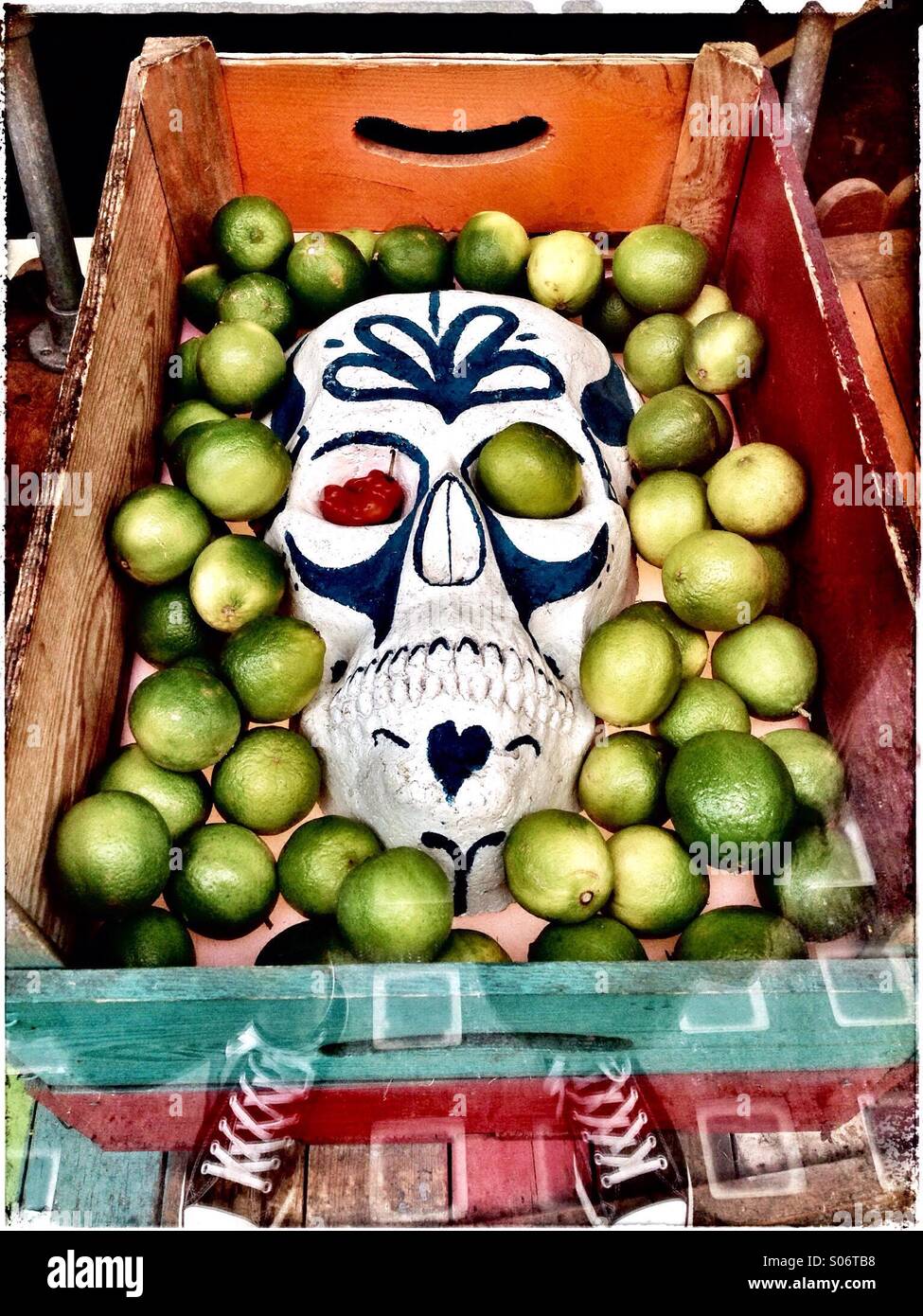 Limas y una máscara calavera Azteca tradicional en una caja Foto de stock