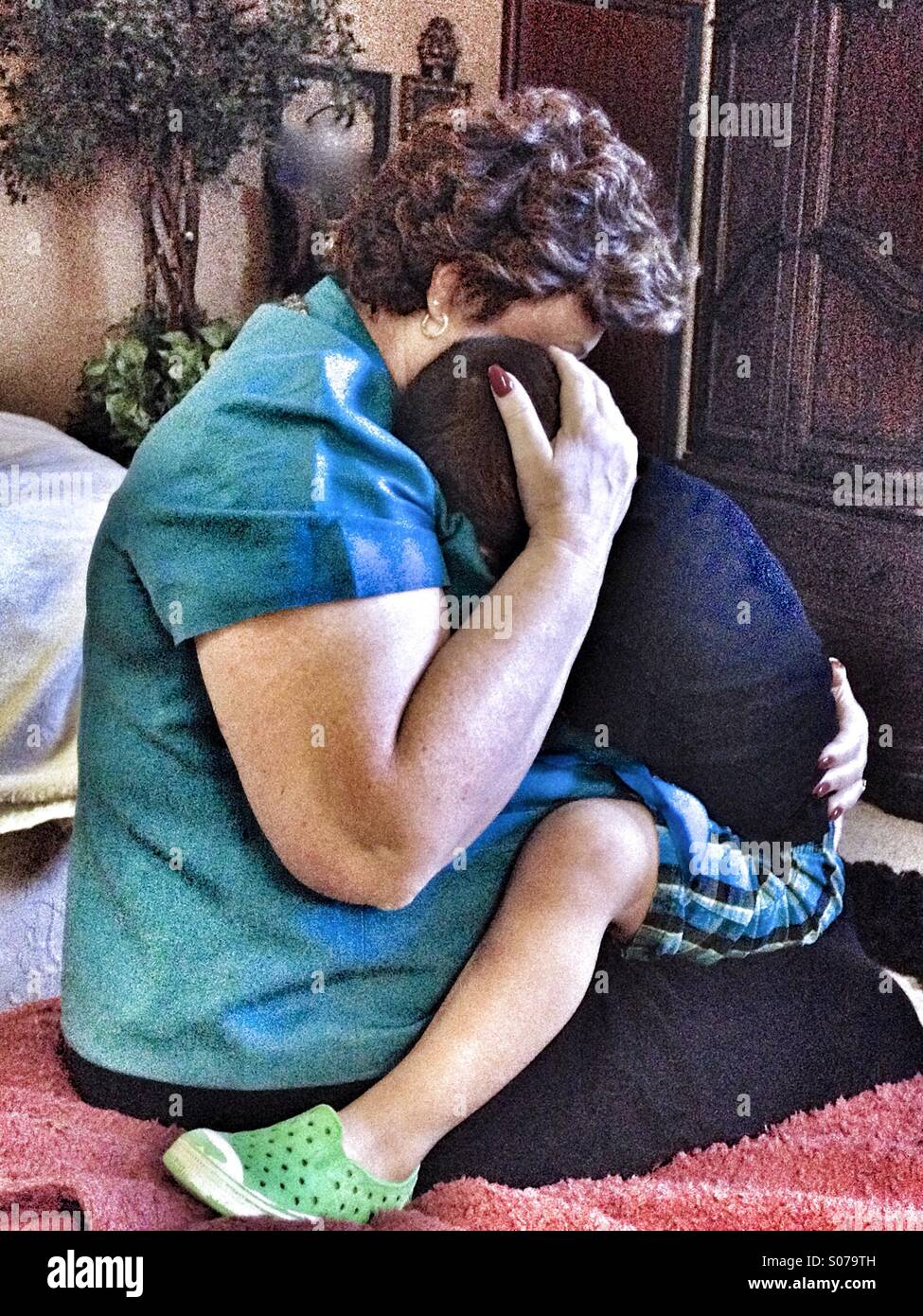 Tocar shot de una abuela holding, abrazos, y consolando a un niño pequeño. Foto de stock