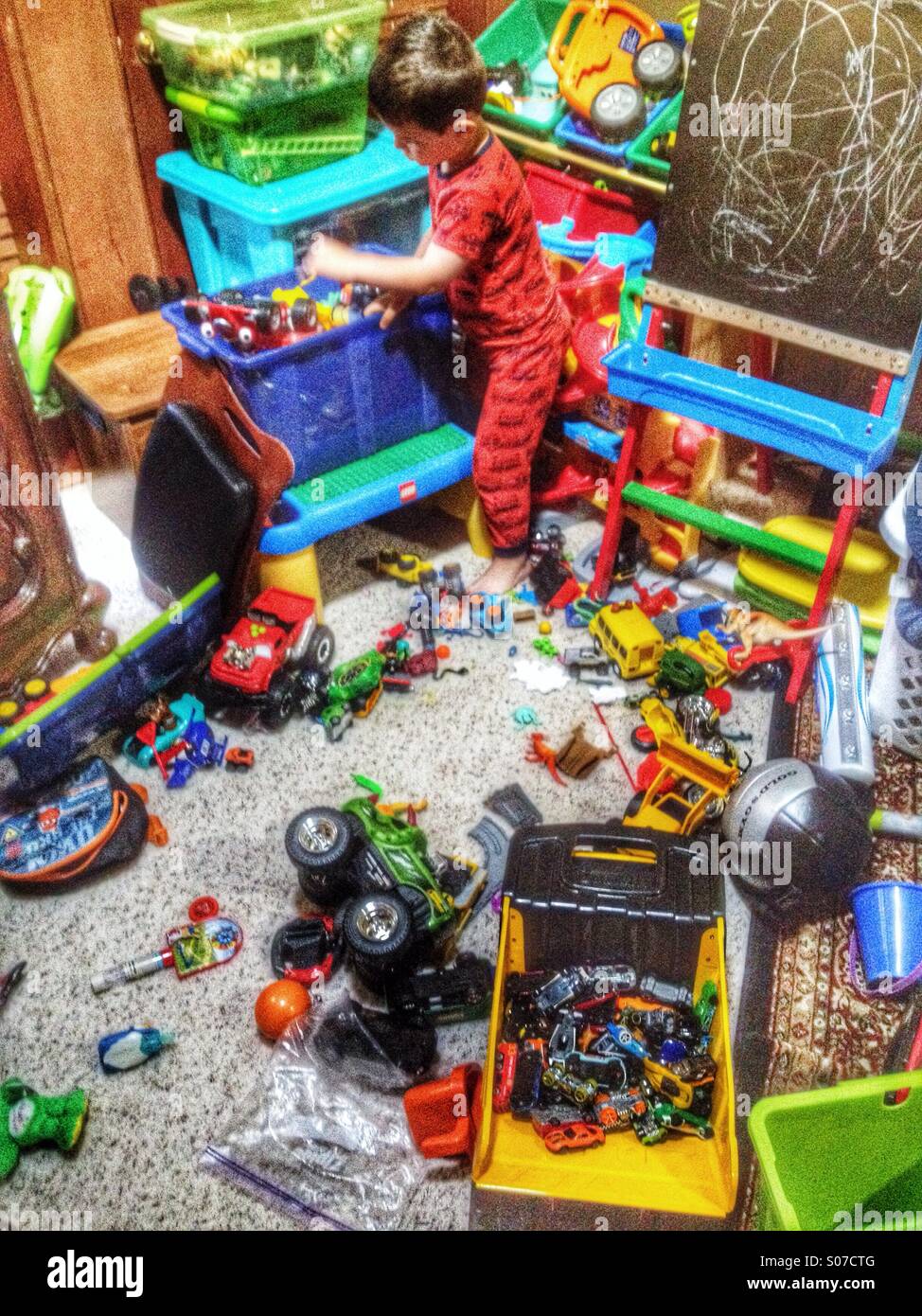 Demasiados juguetes! Niño de 4 años con sus juguetes esparcidos por todo  alrededor de él Fotografía de stock - Alamy