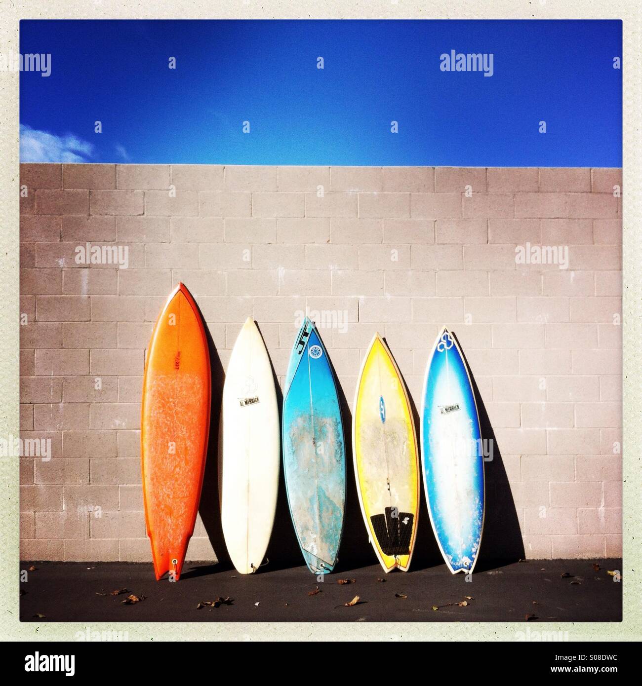 Las tablas de surf coloridos recostada sobre una pared. Foto de stock