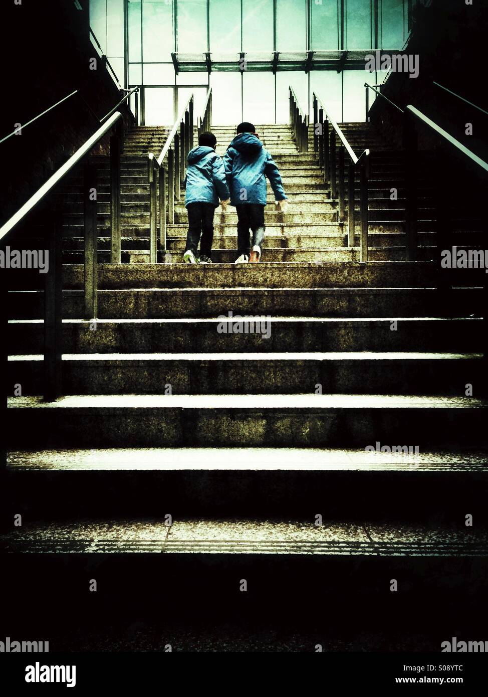 Dos niños caminando por las escaleras en la ciudad Foto de stock
