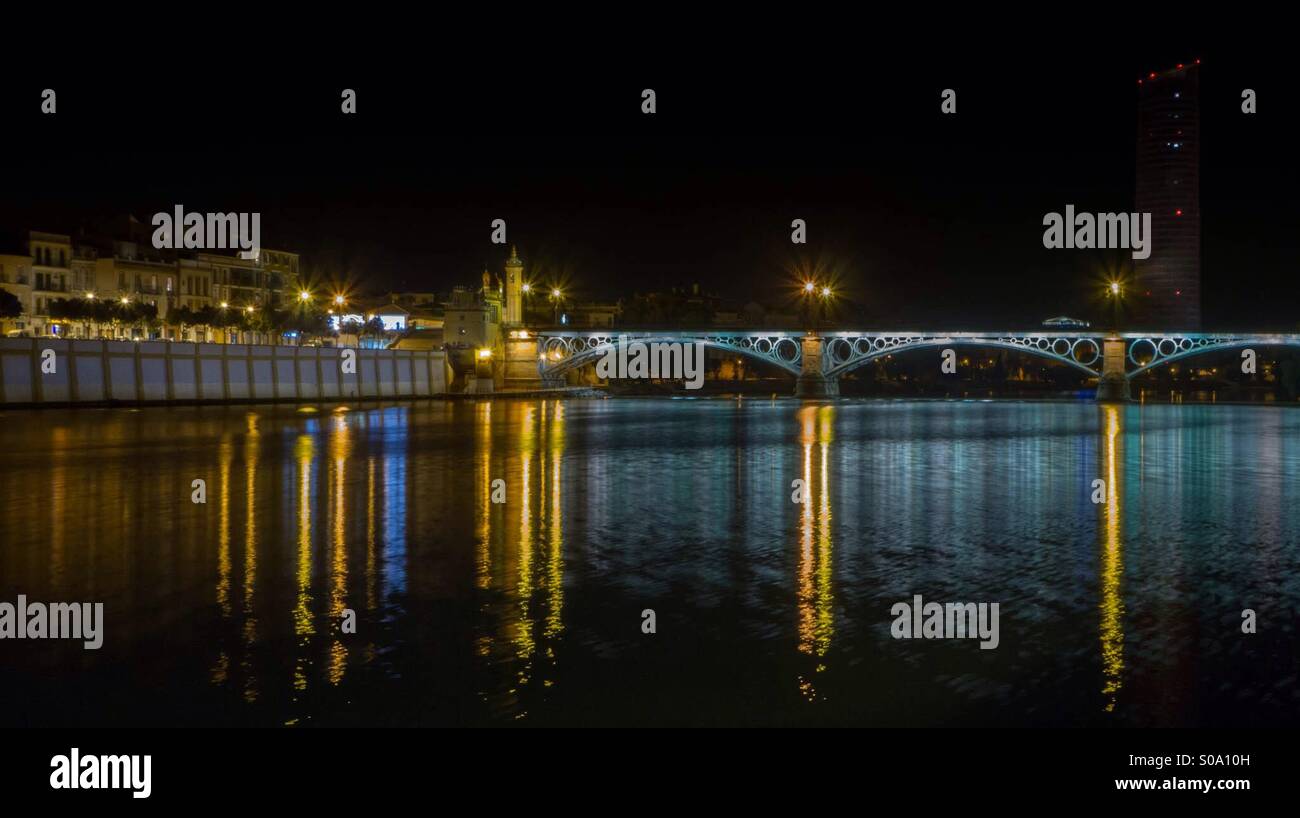 El río Guadalquivir en Sevilla. Noche. Puente de Triana. Torre Pelli. El río Guadalquivir. Noches. Puente de Triana. Sevilla. España. Foto de stock